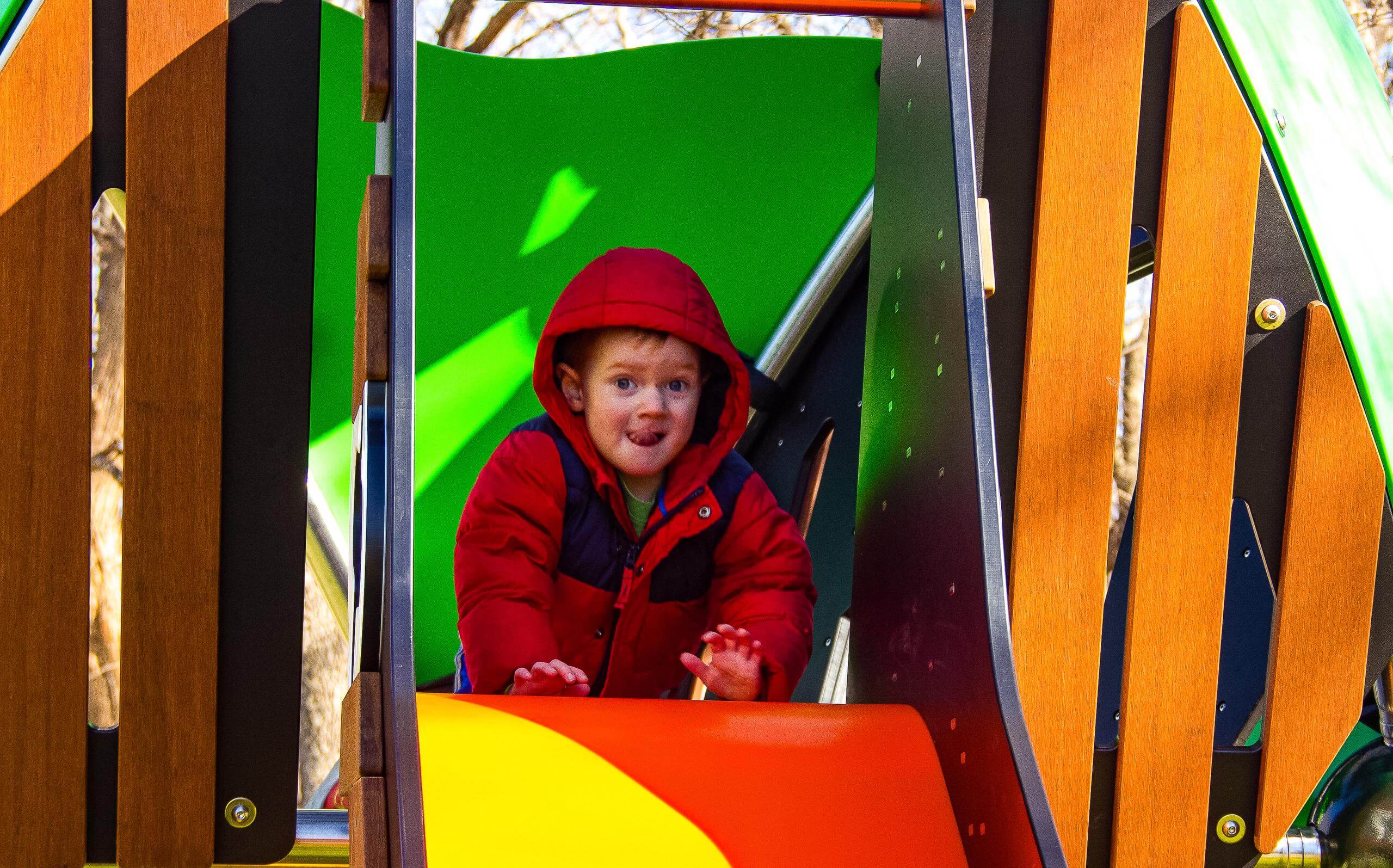 Child at the top of slide with mischievous smile.