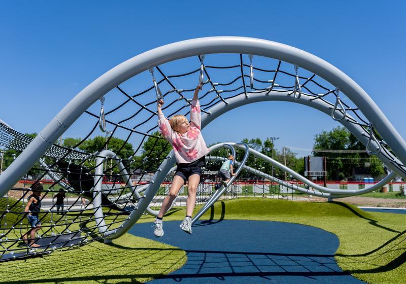 Girl brachiating on a modern playground structure