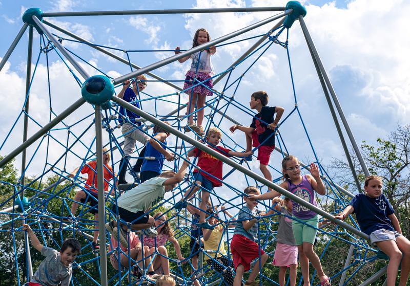 Multiple kids climbing a rope structure.