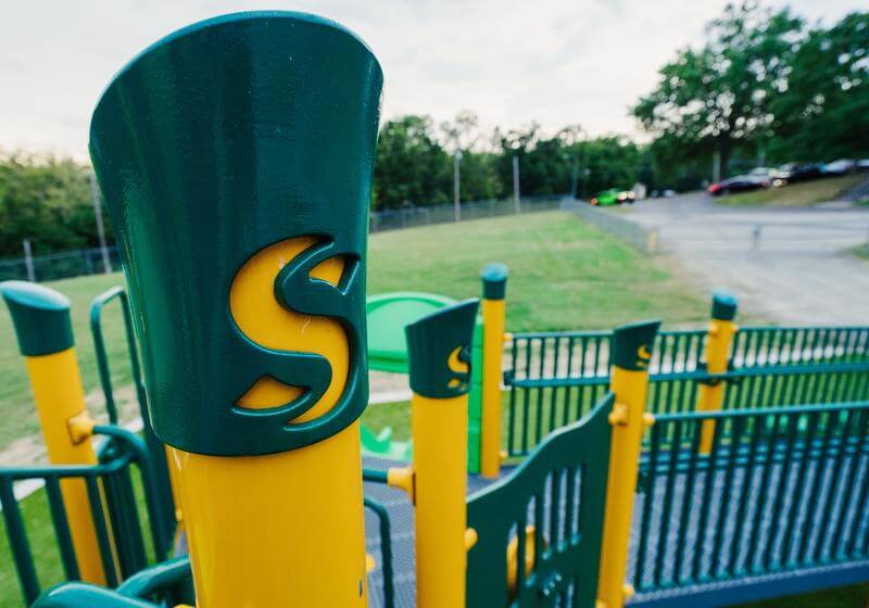 Close up shot of bright yellow and green playground structure